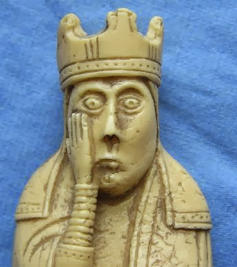ivory chess piece with hand on face, looking astounded